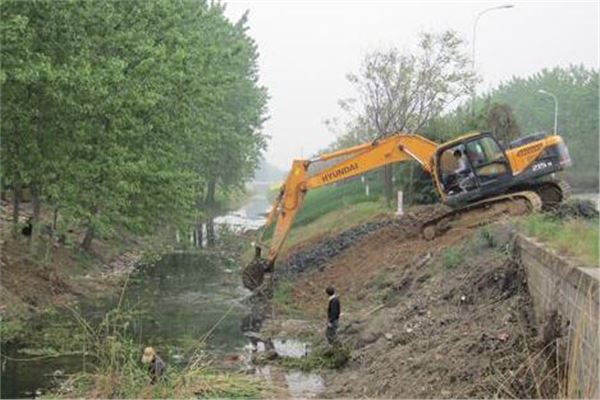 郴州市河道清理公司江河湖清淤 河道清淤疏浚时,先由人工将河道淤泥挖运上岸,再用挖掘机、装载机和汽车配合清运疏掏土方。在清运淤泥时,就立即派人将道路上撒落的土方清扫干净,给周边市民一个良好的居住环境。该河道部分堤段堤顶上是绿化带斜坡,斜坡顶上才能行驶运输机械,挖掘机械等都不能下到河道内疏掏淤泥。其他河段我们考虑使用挖掘机械直接开下河道内进行淤泥疏掏,但摸底河全段都没有下河马道,我们考虑在摸底河适当位置采用硅块铺设临时下河马道。根据现场情况,下河马道需要设3处。在河床淤泥清运完毕后,由人工拆除硅块下河马道。